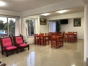 a dining room with wooden tables and chairs at Hostería Ostende in Ostende