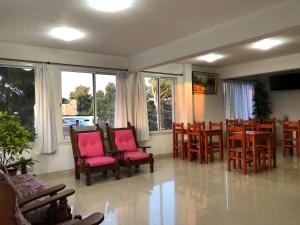 a dining room with chairs and tables and windows at Hostería Ostende in Ostende