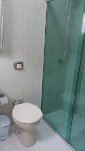 Un baño con inodoro y ducha de cristal. en Apartamento no centro - 2, en Balneário Camboriú