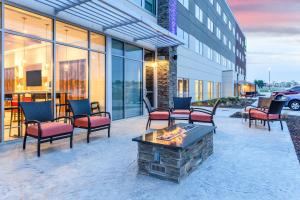 a patio with chairs and a fire pit in front of a building at Holiday Inn Express & Suites - Springfield North, an IHG Hotel in Springfield