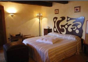 a bedroom with a large bed and a lamp at Villa Poggio Aperto in Seggiano