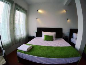 a bedroom with a large bed with green sheets at Ella Ravana Seetha Mountain View Villa in Ella