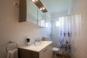 a bathroom with a sink and a toilet and a shower at Guesthouse Ksenija in Komiža +35 photos