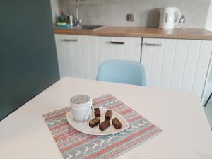 a plate of cookies and a cup of coffee on a table at Apartment near Old Town - Długie Ogrody in Gdańsk