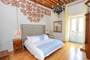 Un dormitorio con una cama grande y una lámpara de araña. en Hotel Mansion Von Humboldt, en Guanajuato