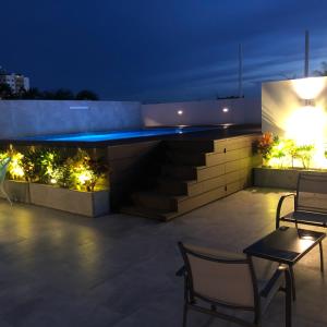 a patio at night with two chairs and lights at Sibaris cañoto in Santa Cruz de la Sierra