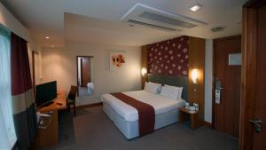 سرير أو أسرّة في غرفة في Holiday Inn Manchester - Central Park, an IHG Hotel