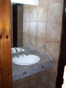 a bathroom with a sink and a mirror at Chalets Los Abedules in Villa General Belgrano +20 photos
