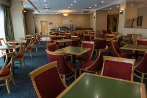 una sala da pranzo con tavoli e sedie di Holiday Inn Express Saltillo Zona Aeropuerto by IHG a Saltillo Altre 45 foto