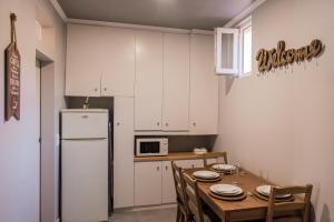 eine Küche mit einem Tisch und einem weißen Kühlschrank in der Unterkunft Apartamento ideial in Lissabon