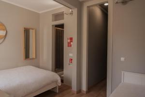 リスボンにあるApartamento ideialのベッドルーム1室(ベッド1台付)、廊下へのドアが備わります。