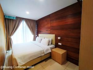 a bedroom with a bed and a wooden wall at Kluang Container Swimming Pool Hotel in Kluang