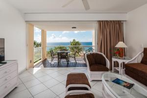 a living room with a view of the ocean at Sxmile - 1 BR A in Cupecoy