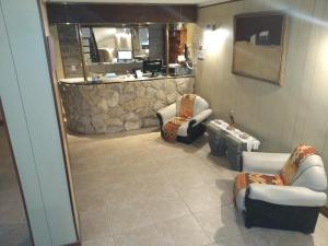 sala de estar con sillas y pared de piedra. en Hotel Saona en Mar del Plata