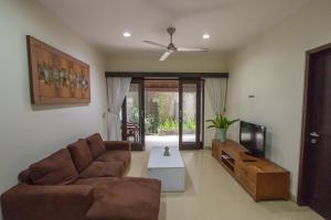 a living room with a couch and a tv at Bali Paradise Apartments in Sanur