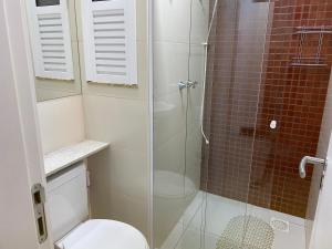 y baño con ducha de cristal y aseo. en Arraial do Cabo-Apartamento para temporada-Condomínio Golden Lake, en Arraial do Cabo