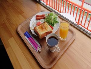bandeja de desayuno con plato de comida y bebida en Sea Side Hostel Light House, en Onomichi