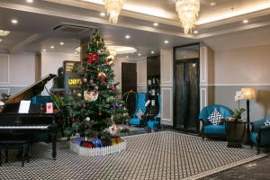 ハノイにあるImperial Hotel & Spaのピアノ付きの部屋のクリスマスツリー