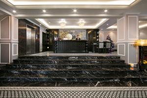 un vestíbulo con escaleras y un bar en el fondo en Imperial Hotel & Spa, en Hanói