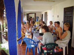 Hotel Amar Inn في بويرتو موريلوس: مجموعة من الناس يجلسون على الطاولات في الغرفة