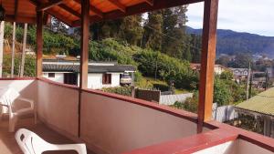 a balcony with a view of a house at Oviya Guest in Nuwara Eliya