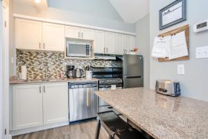 a kitchen with white cabinets and a granite counter top at Blue Mountain Studio Loft at North Creek Resort in Blue Mountains