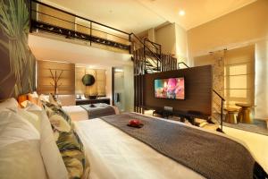 a bedroom with two beds and a flat screen tv at Sojourn Spa Hotel Ipoh in Ipoh