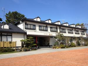 a building with a tennis court in front of it at Ocean View Hamayu in Makinohara