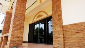 een extern uitzicht op een gebouw met grote ramen bij Narakorn House in Buriram