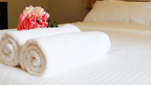 een boeket rozen op een bed bij Narakorn House in Buriram