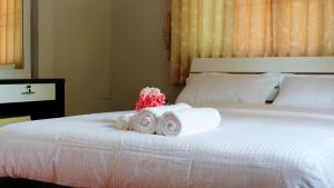 Una cama con tres rollos de toallas. en Narakorn House, en Buriram
