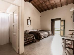 a bedroom with two beds and a table and a door at Balcones del Parque Jardin in Jardin