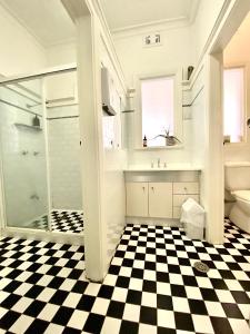 a bathroom with a glass shower and a checkered floor at Newcastle Hotel in Newcastle