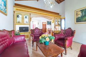 a living room with red leather furniture and a table at RedDoorz Syariah near Balai Kota Batu in Malang