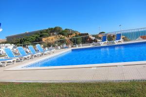 a large swimming pool with lounge chairs and a building at Duplex - Varandas Do Mar Patricia in Albufeira