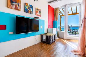 a living room with a large flat screen tv on a wall at Fei Li Jin Hotel in Kenting