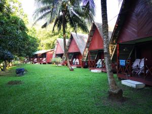 un grupo de casas con palmeras en el patio en Puteri Salang Inn en Tioman Island