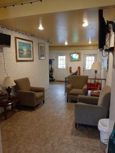 uma sala de estar com sofás e cadeiras e uma televisão em Clarysville Motel em Frostburg