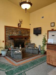 sala de estar con chimenea de piedra con sofás y TV en Clarysville Motel, en Frostburg