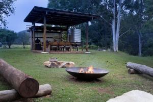 a fire pit in a yard with a picnic table at Greenlee Cottages in Canungra