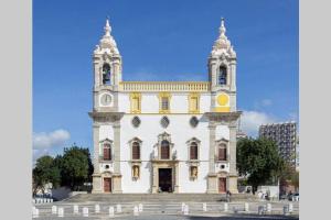 a large white building with a clock tower at REMODELED APARTMENT IN THE CITY CENTER. (FARO) in Faro