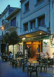 a group of tables and chairs in front of a building at Turó de L´Home in Santa María de Palautordera