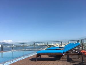 a pool with a blue slide on a deck next to the water at Gold Boutique Hotel Danang in Da Nang