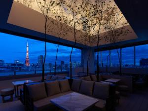 um quarto com um sofá e vista para a torre Eiffel em Mitsui Garden Hotel Roppongi Tokyo Premier em Tóquio