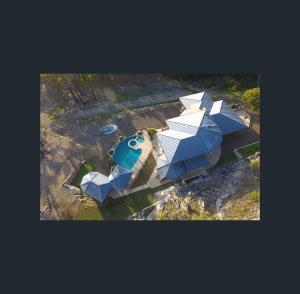 新月岬The Pool House - Crescent Head - stunning ocean views, pet friendly的享有蓝色和白色屋顶房屋的空中景致