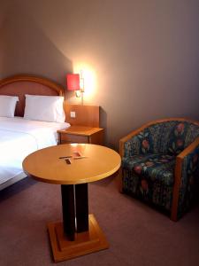 a hotel room with a bed and a table and a chair at Hotel Vianorte in Maia