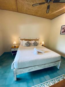 a bedroom with a large bed with two lamps at Jukung Dua Guest House in Sanur