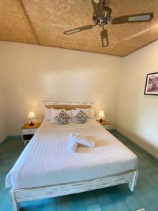 a bedroom with a white bed with two lamps at Jukung Dua Guest House in Sanur