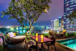 a table and chairs on a balcony with a city skyline at Silverland Jolie Hotel in Ho Chi Minh City