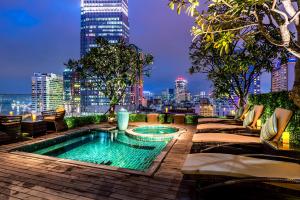 a swimming pool on top of a building with a city skyline at Silverland Jolie Hotel in Ho Chi Minh City